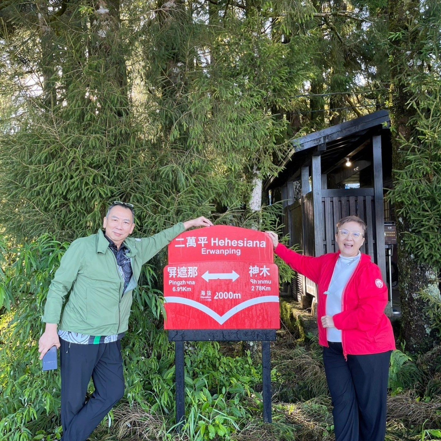 A man and a woman standing next to a sign that says hehealing