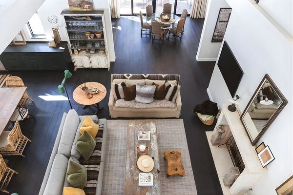 Overhead view of a modern living room with sofa, rug, TV, and dining area beyond.