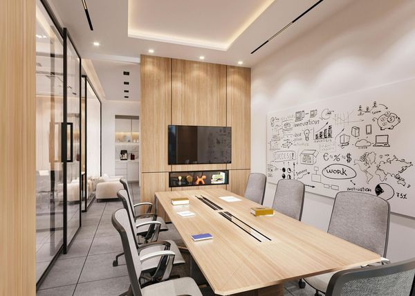 Modern office meeting room with wooden table, gray chairs, wall TV, and white doodle art wall