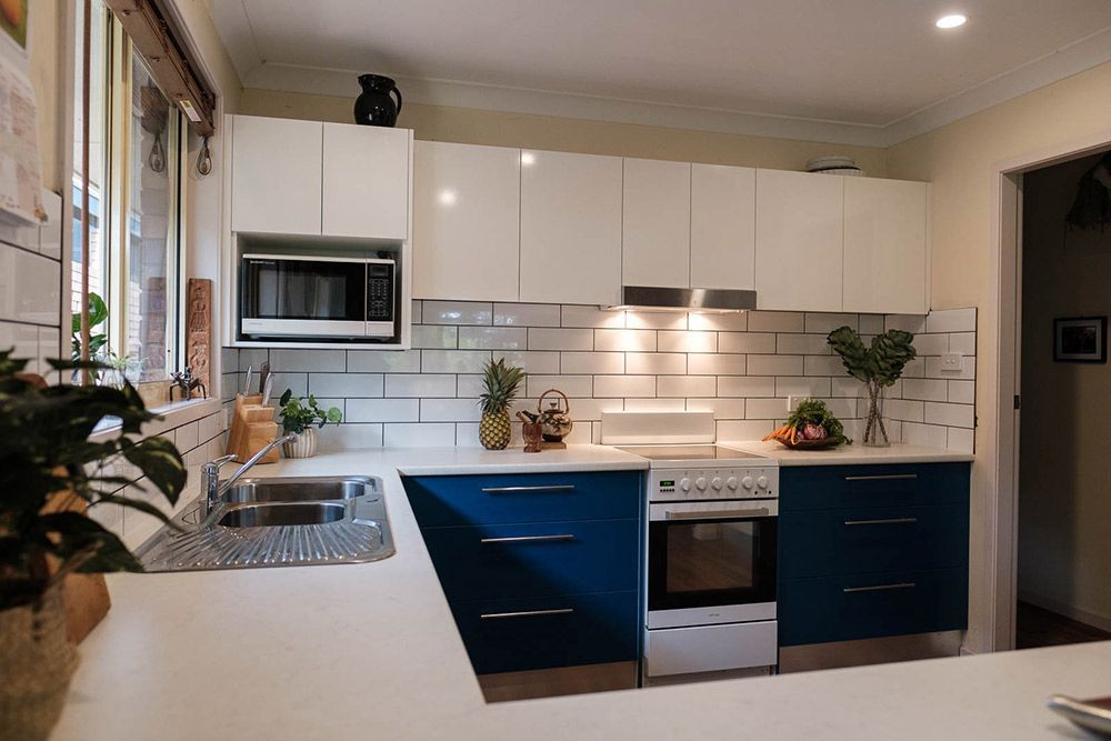 A Kitchen With Blue Cabinets — Flow Kitchens in Harrington, NSW