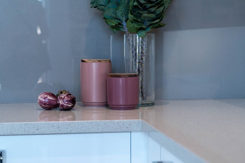 A Kitchen Counter With a Vase of Flowers and Candles on It — Flow Kitchens in Gloucester, NSW