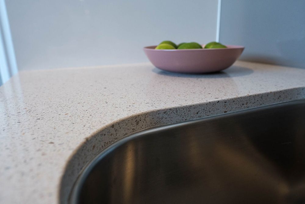 A Bowl of Limes is Sitting on a Counter Next to a Sink — Flow Kitchens in Hallidays Point, NSW