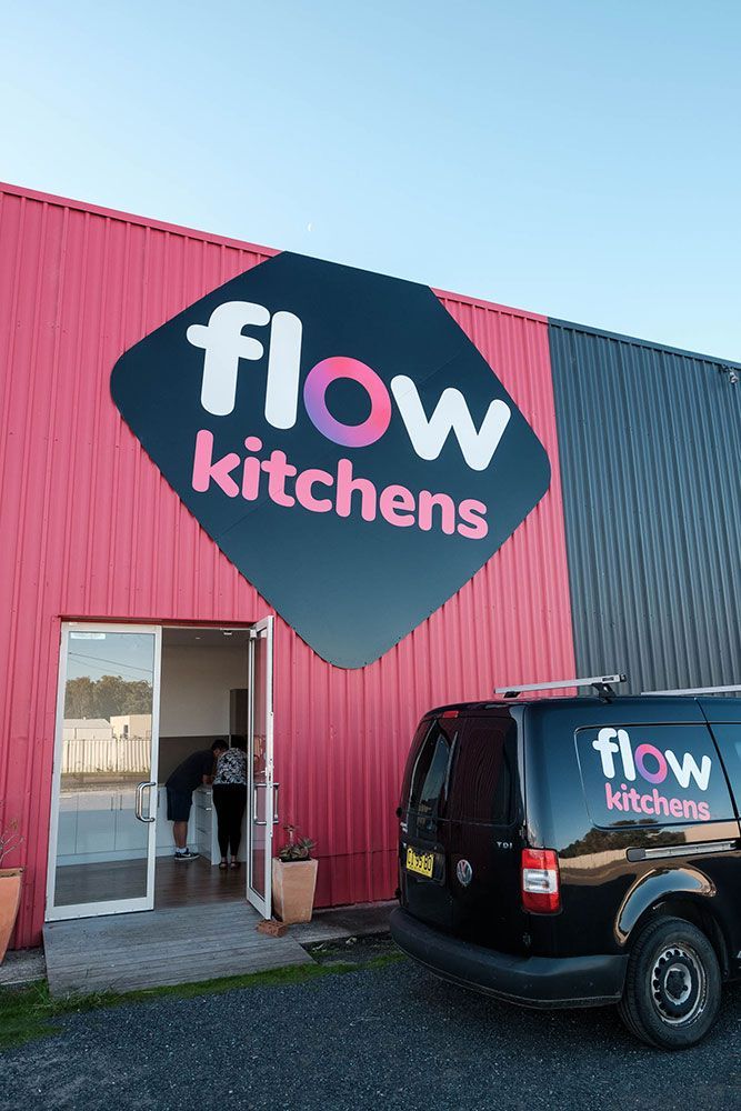 A Black Van is Parked in Front of a Building That Says Flow Kitchens — Flow Kitchens in Taree South, NSW
