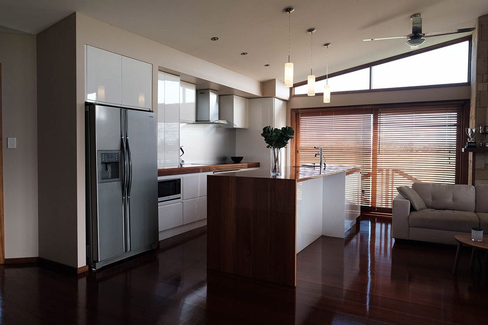 A Kitchen With a Stainless Steel Refrigerator and a Sliding Glass Door — Flow Kitchens in Taree South, NSW