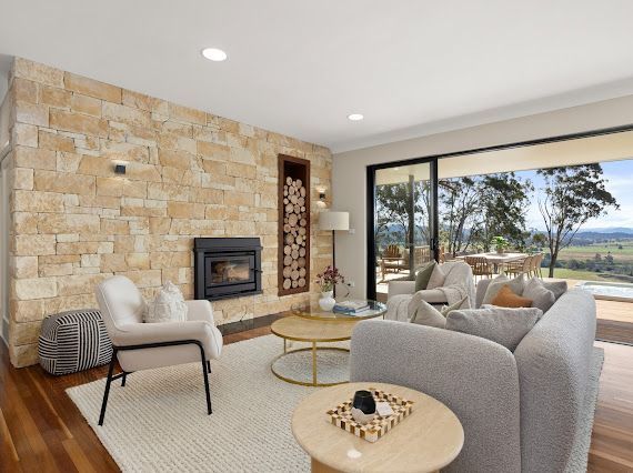 Living Room With Stone Fireplace, Wood-filled Alcove, and Scenic Outdoor View Through Sliding Glass Doors — Flow Kitchens in Taree South, NSW
