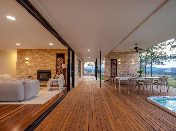 Open Plan House With Wooden Deck, Sliding Glass Doors, Stone Fireplace, Outdoor Dining, and Hot Tub — Flow Kitchens in Taree South, NSW