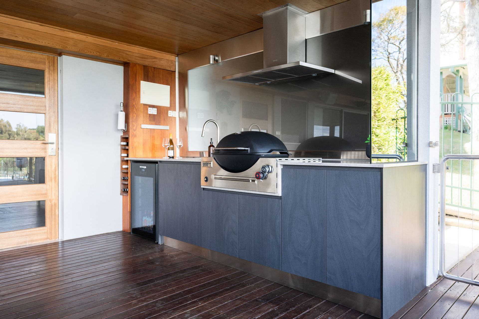 Outdoor Kitchen With a Grill, Stainless Steel Hood, and Dark Blue Cabinetry — Flow Kitchens in Taree South, NSW