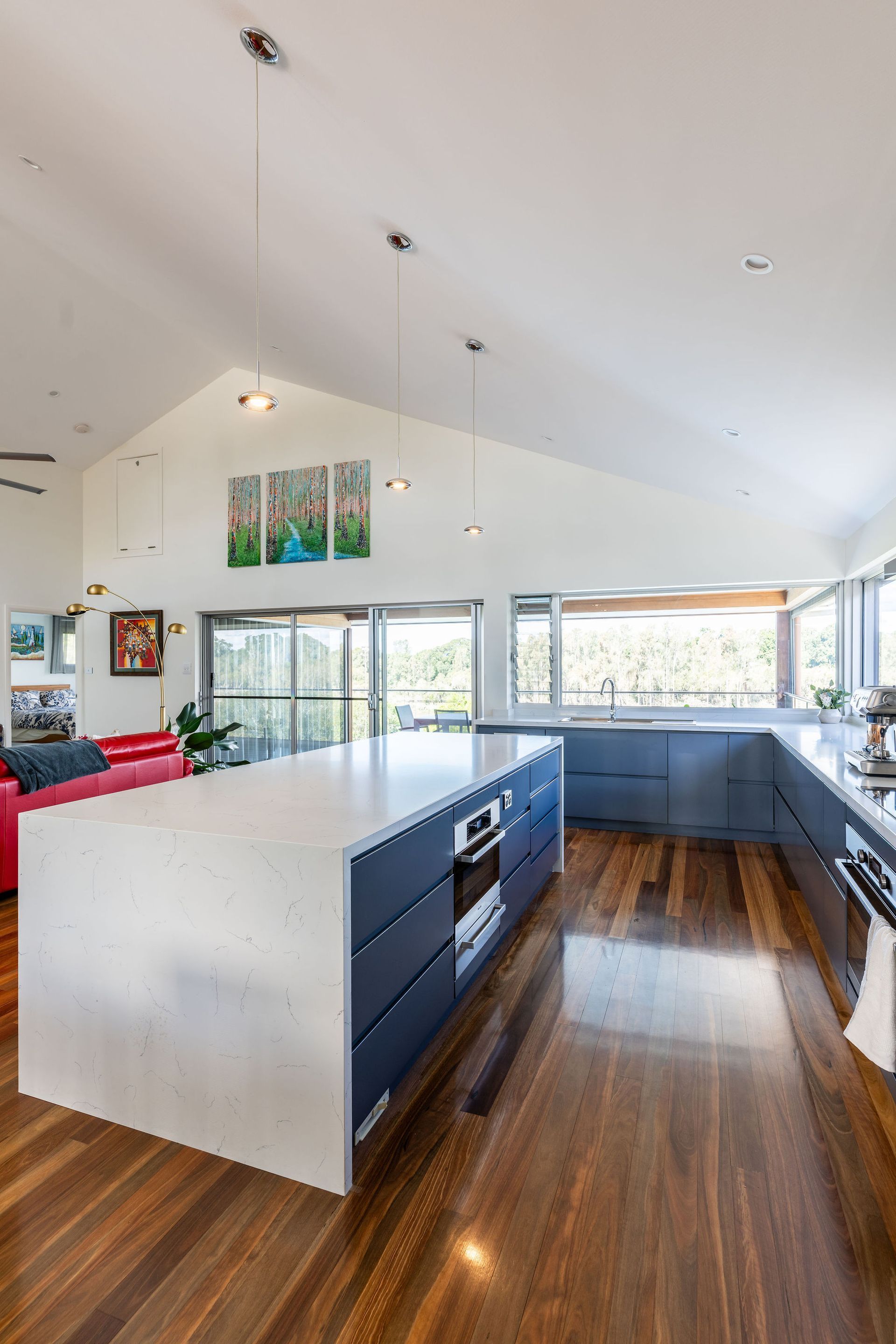 Modern Kitchen With Large Island, Blue Cabinets, White Countertops, and Hardwood Floors — Flow Kitchens in Taree South, NSW