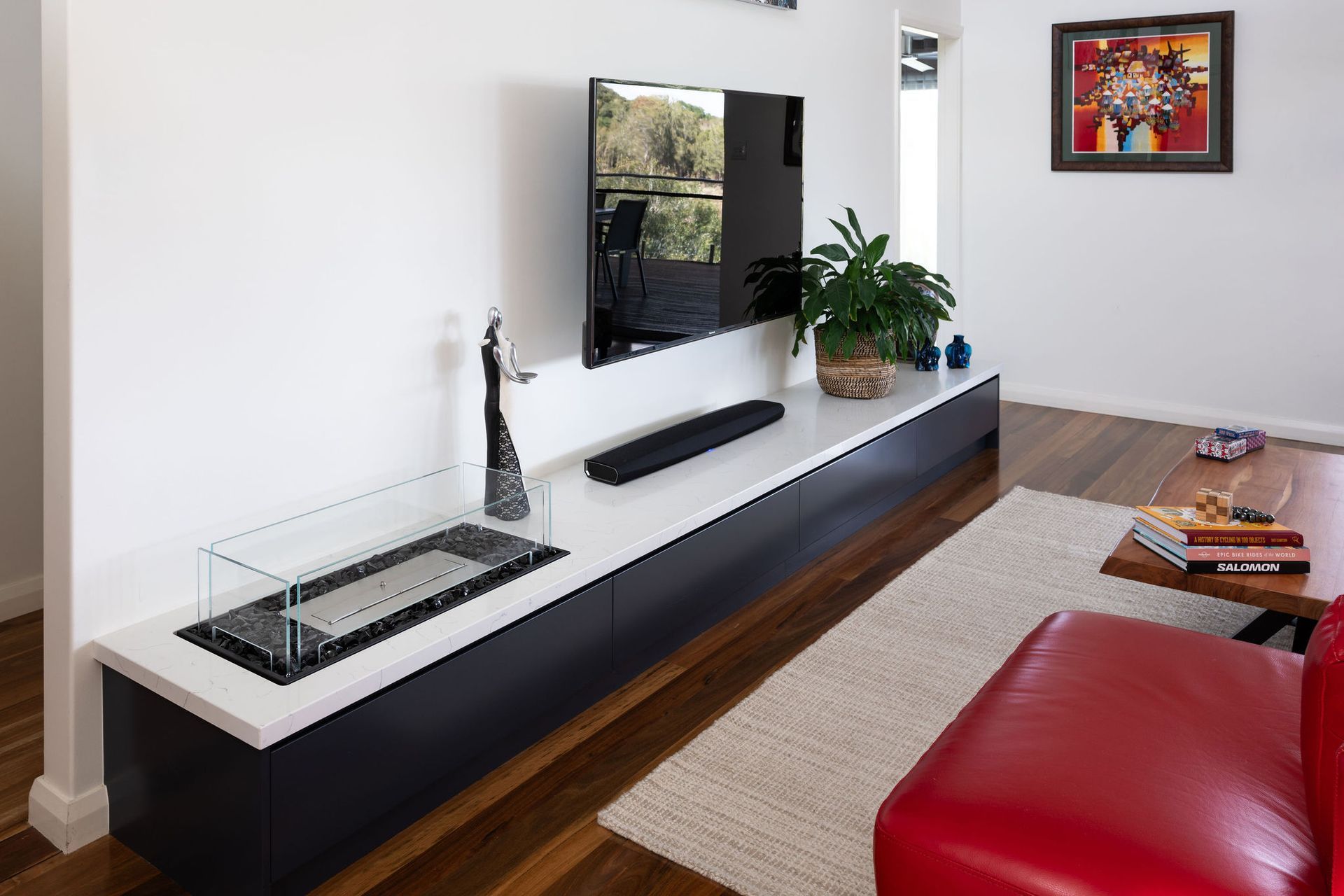 Modern Living Room With Mounted Tv, Floating Media Console, a Fireplace, and Red Couch — Flow Kitchens in Taree South, NSW