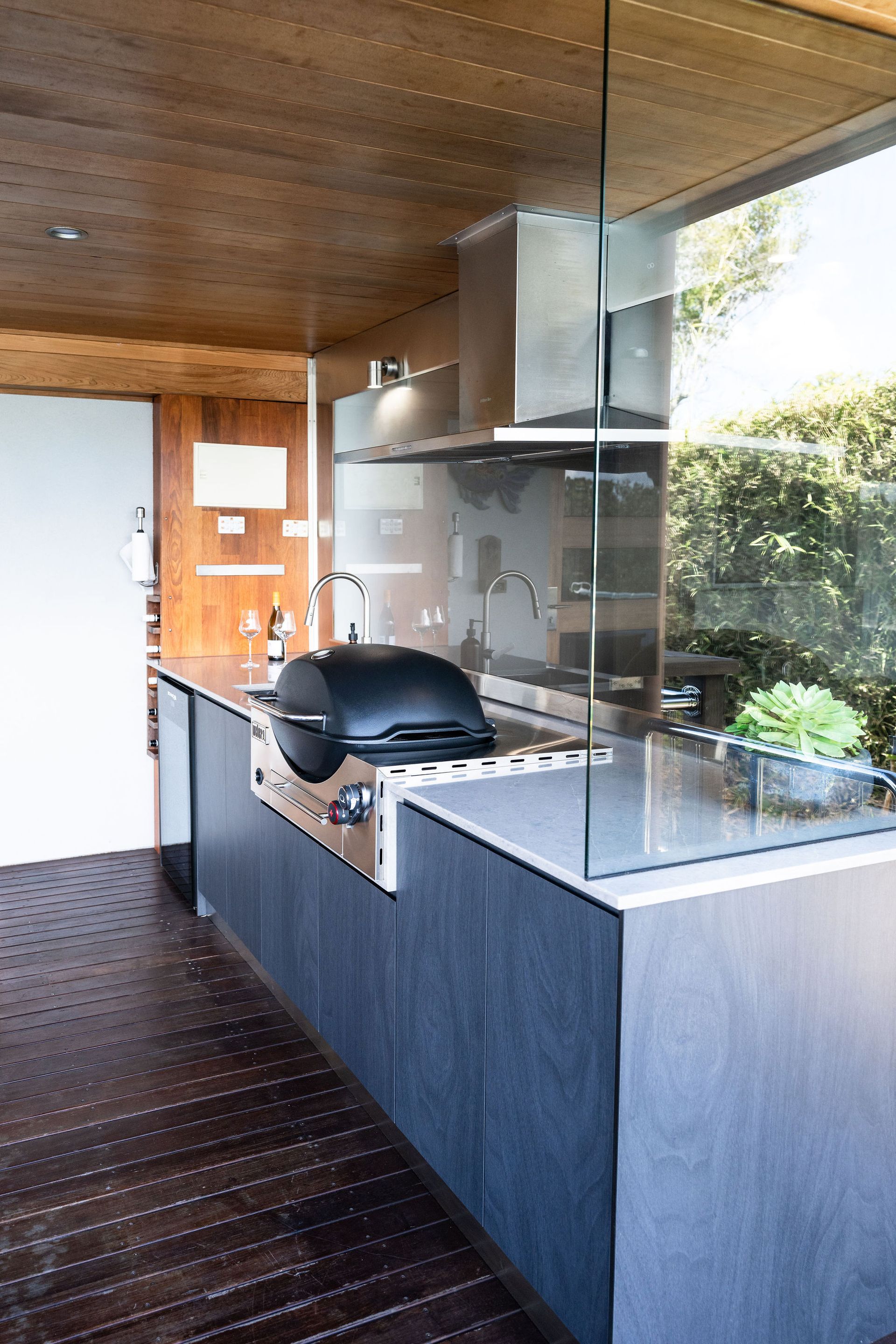 Outdoor Kitchen With Built-in Grill, Stainless Steel Hood, and Glass Partition — Flow Kitchens in Taree South, NSW