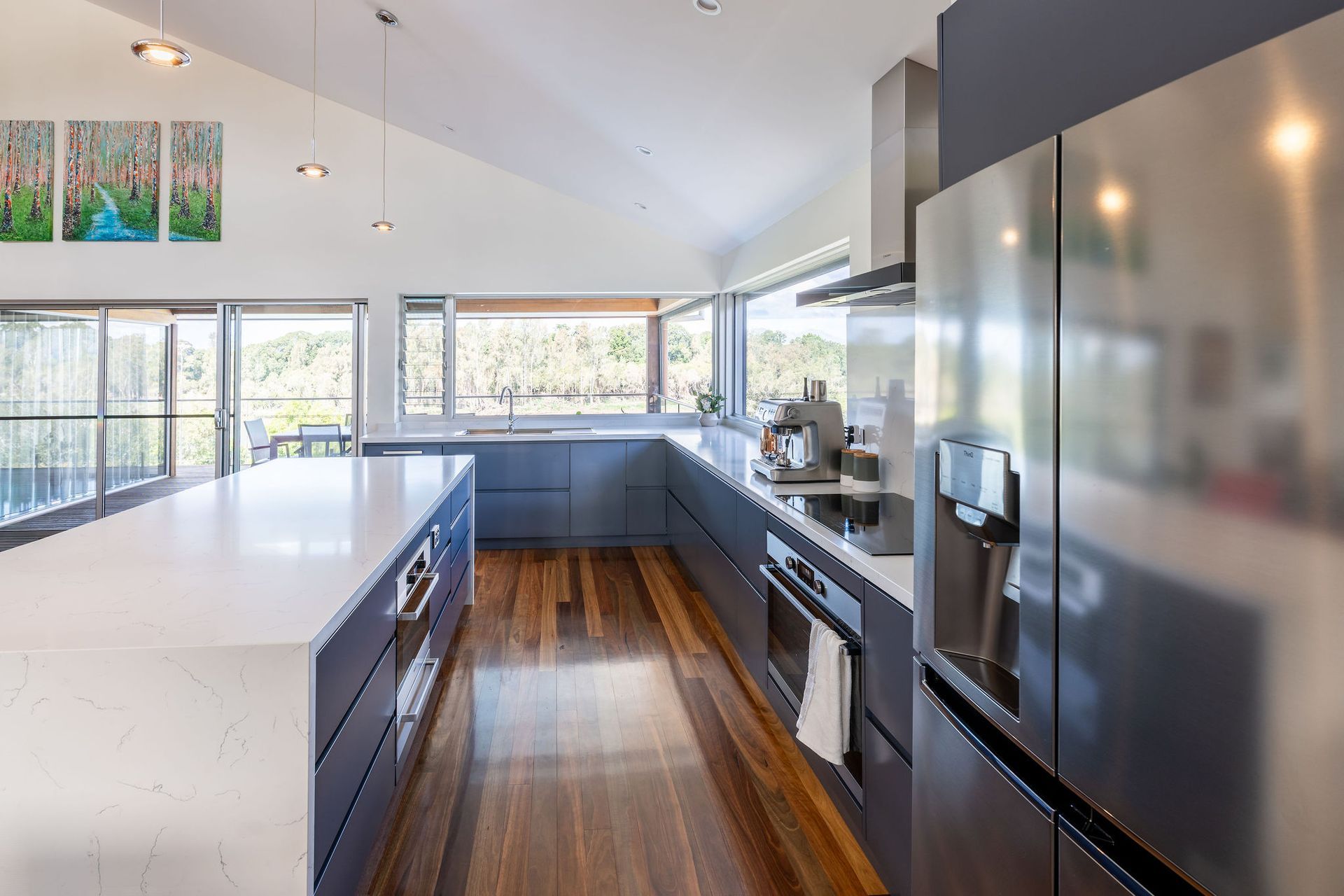 Modern Kitchen With Gray Cabinets, White Countertops, Stainless Steel Appliances, and Wooden Floors — Flow Kitchens in Taree South, NSW