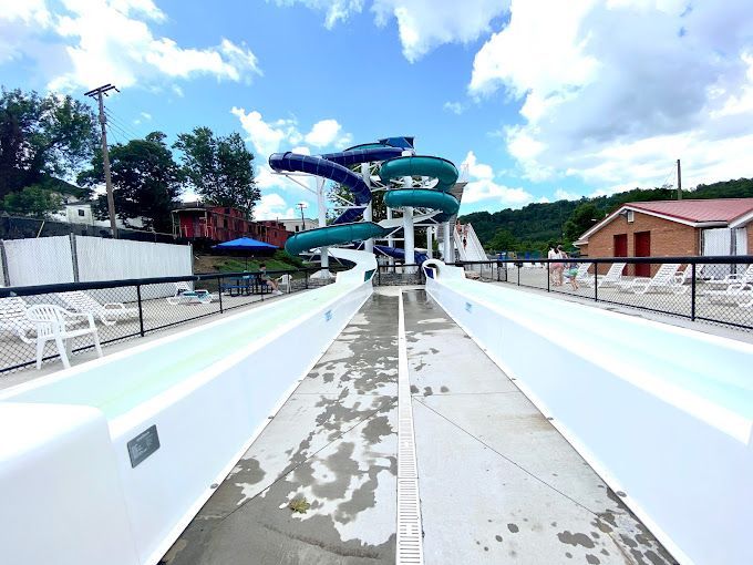 A woman is carrying a child in a backpack on a path in the woods.