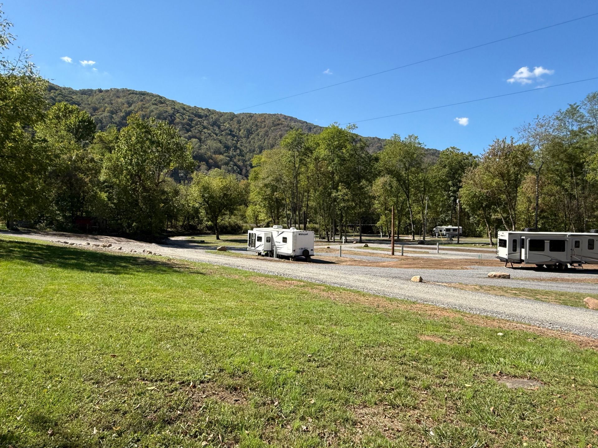 A group of rvs are parked in a grassy field.