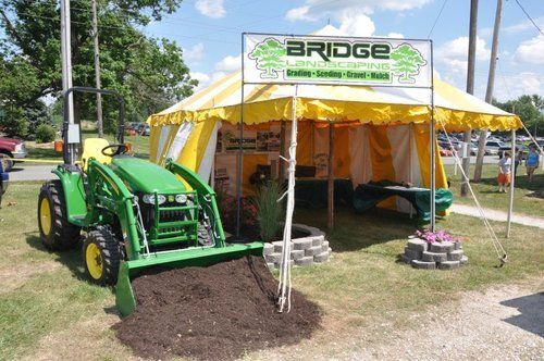 Green Tractor Beside A Tent — Sharpsville, IN — Bridge Landscaping