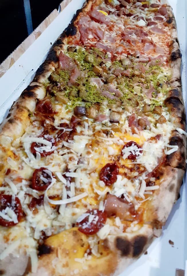 Una pizza con tanti condimenti è in una scatola