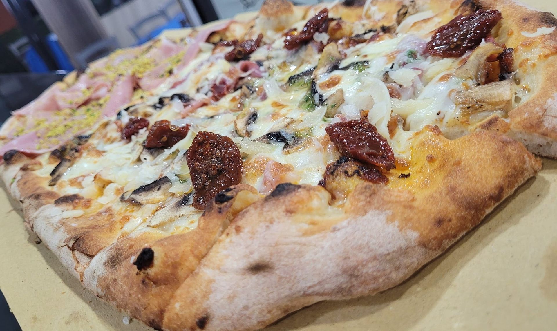 Una pizza con tanti condimenti è appoggiata su un tavolo.