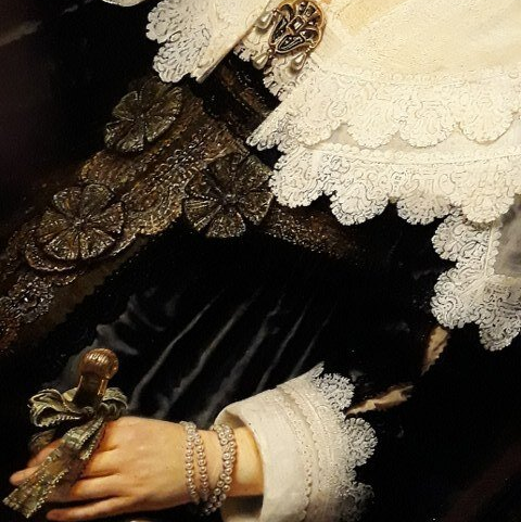Een detail van een portret van Maria Trip door Rembrandt van Rijn met een mouw en halsdoek gemaakt van het fijnste kant en een parelarmband