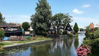 Wooden craftsmen houses along a tiny canal in Edam a famous fishing village near Amsterdam