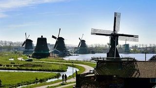 six windmills on a row along the dike of the Zaan river at the windmill village Zaanse Schans near Amsterdam