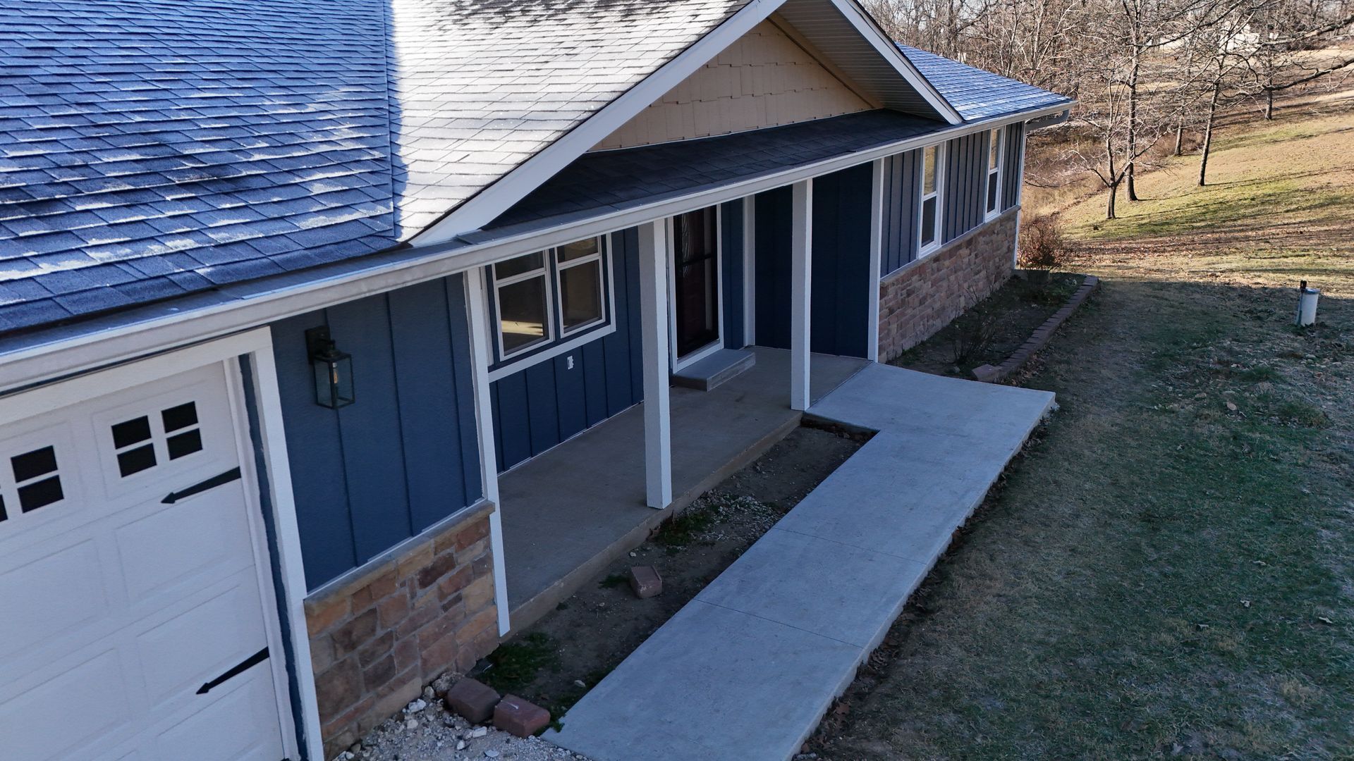 A house with a gray garage door and arched windows | siding and windows springfield mo