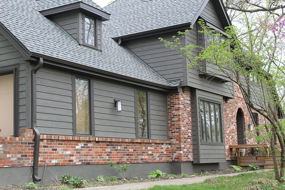 A house with a gray garage door and arched windows | siding and windows springfield mo