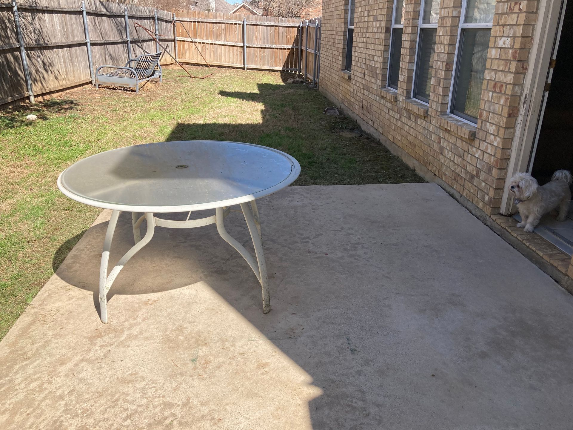 A brick wall with a lot of dirt on the ground in front of it.