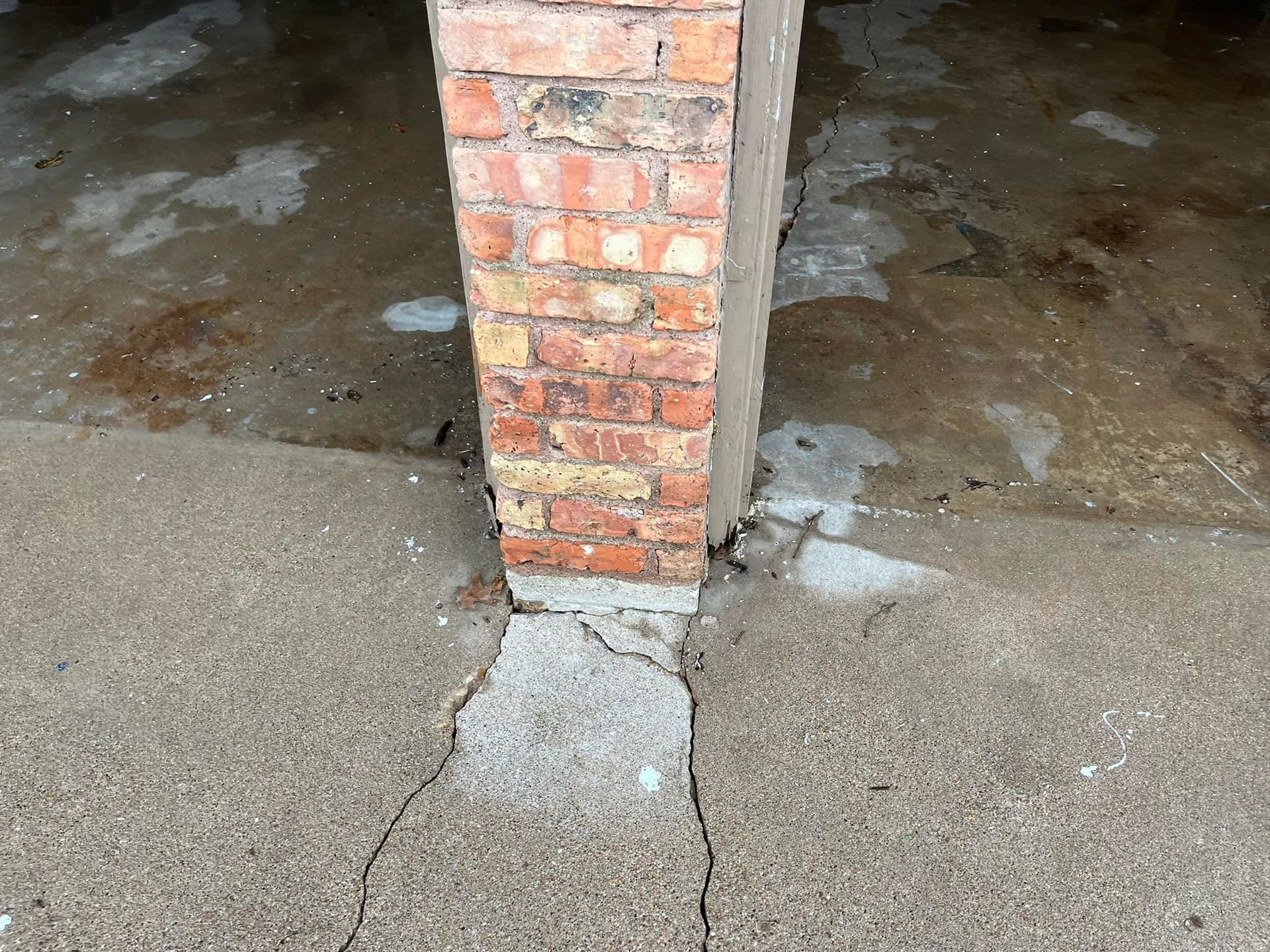 A brick column is sitting on top of a concrete floor.