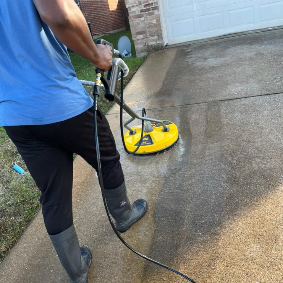 A man is cleaning a driveway with a machine.