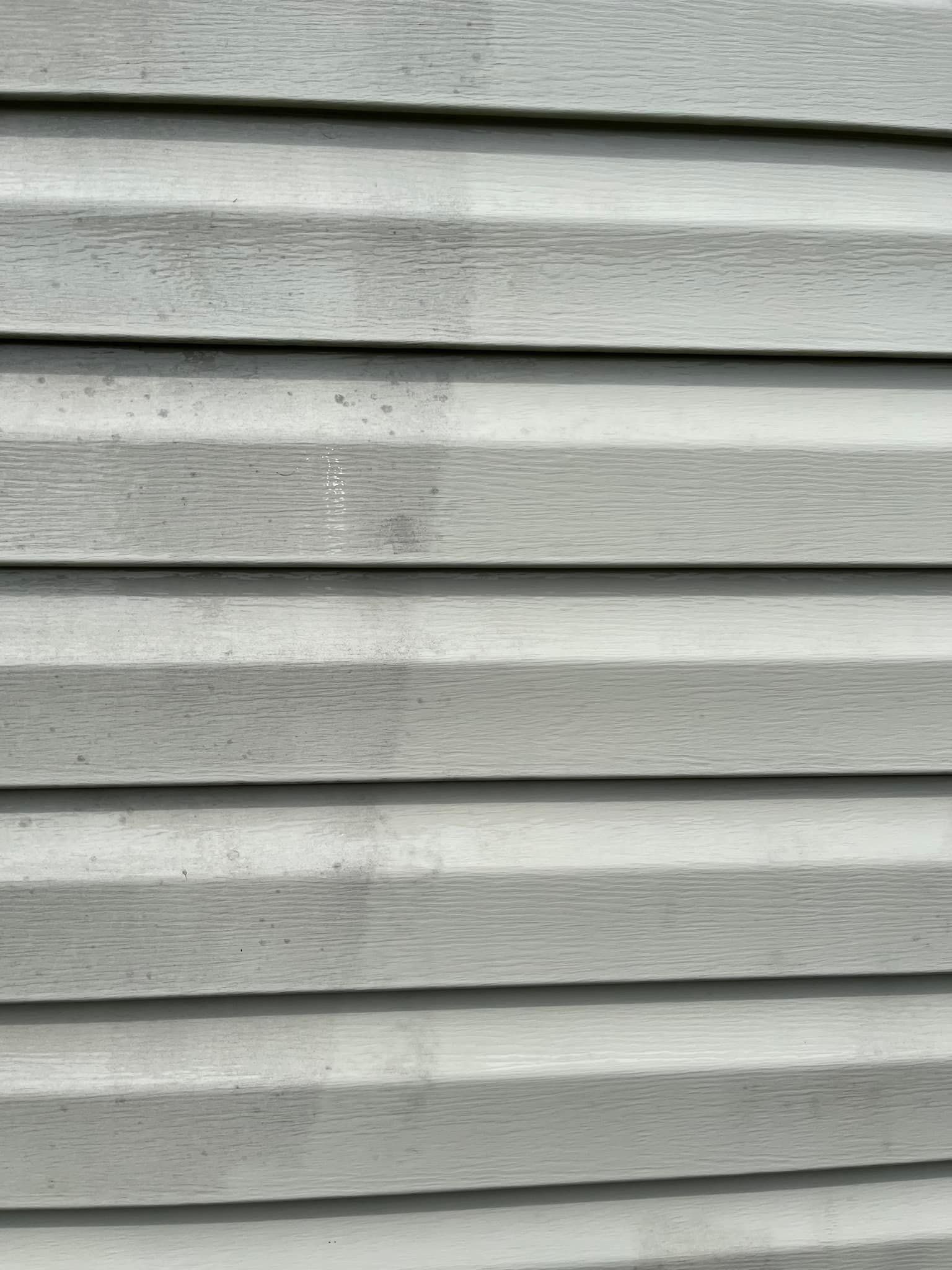 A close up of a gray siding on a house.