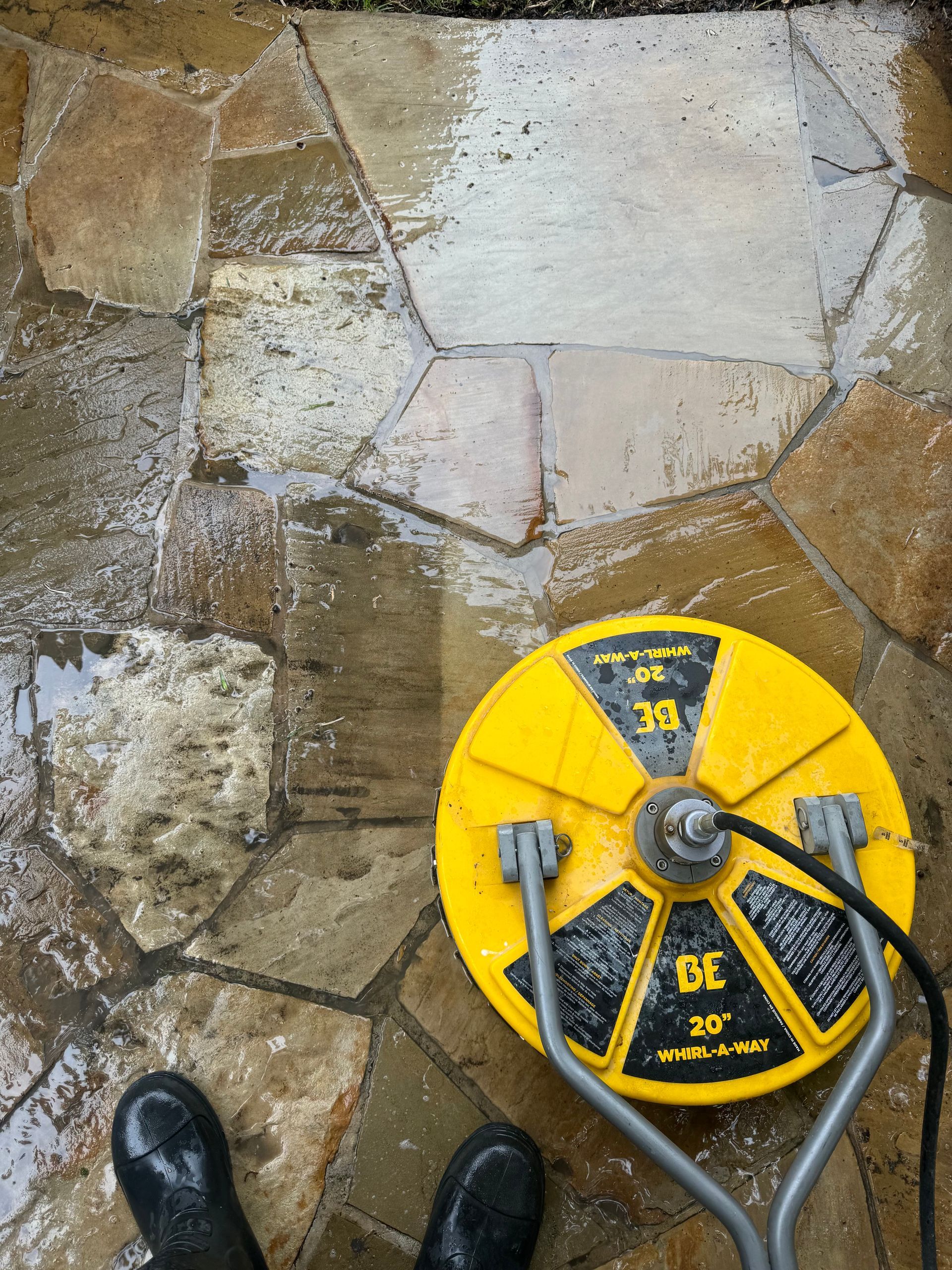 A person is standing next to a yellow machine on a stone floor.