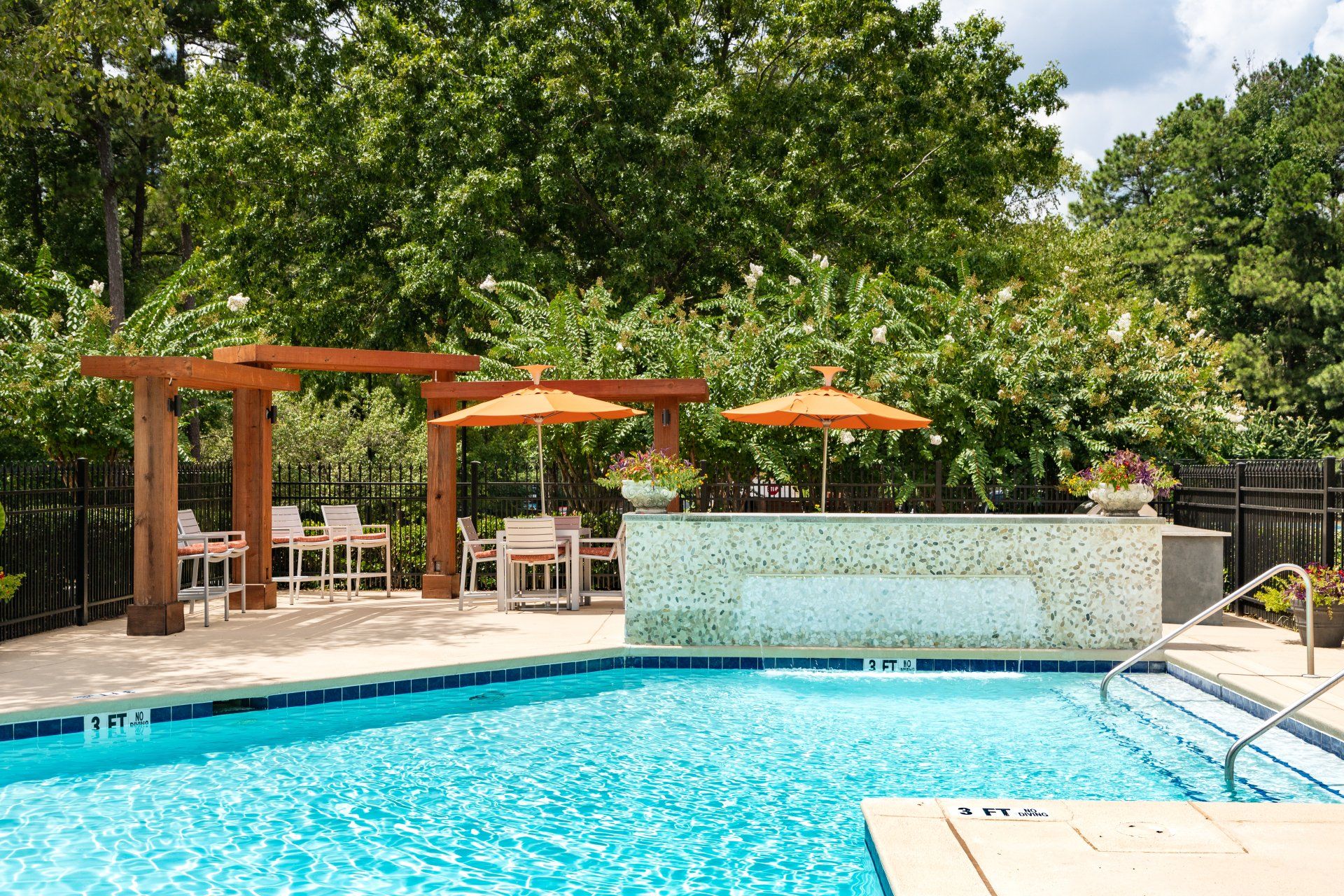 A large swimming pool with umbrellas and chairs around it