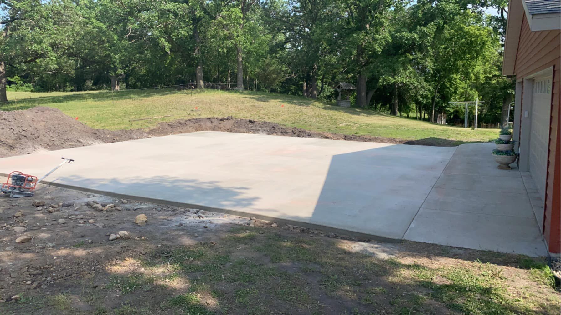 A concrete driveway is being built in front of a house.