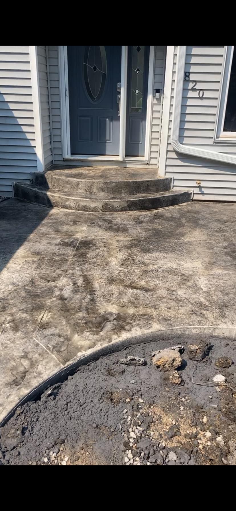 A concrete walkway leading to the front door of a house.