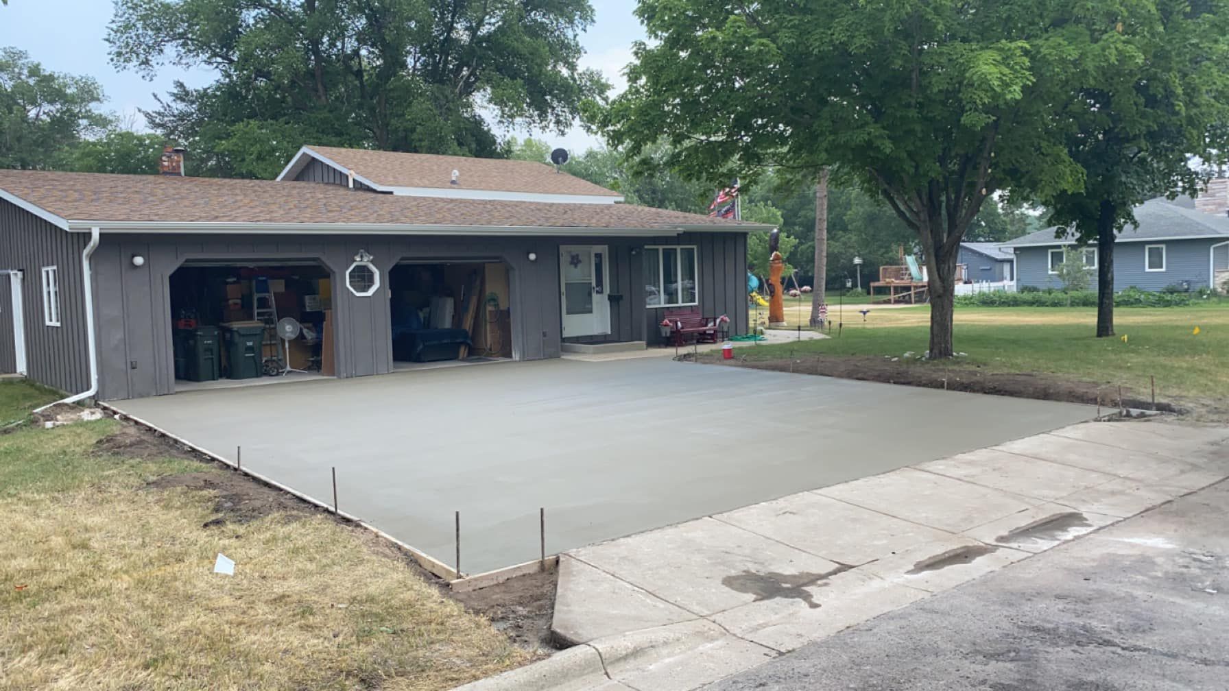 A concrete driveway is being built in front of a house.