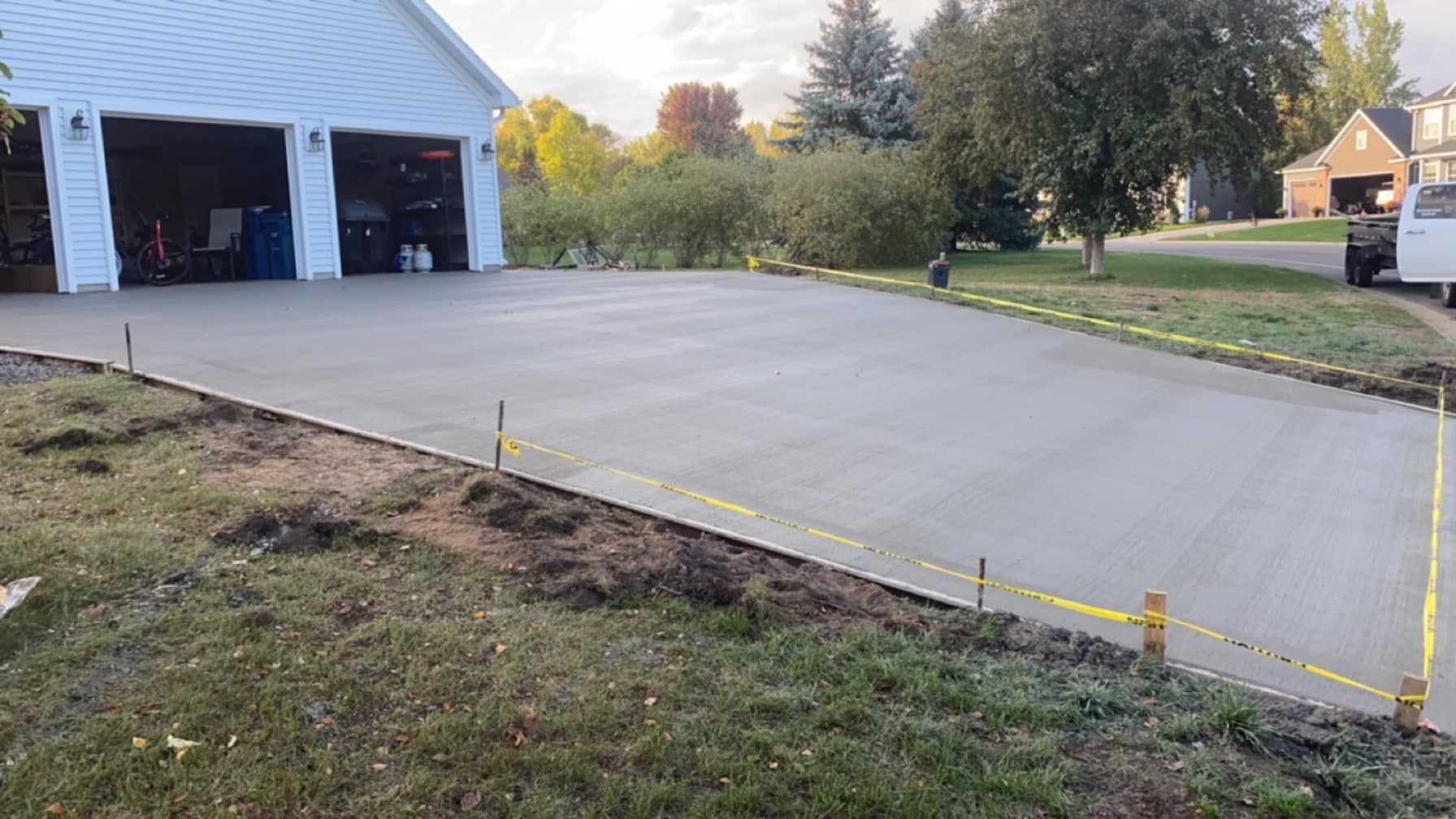 A concrete driveway is being built in front of a garage.