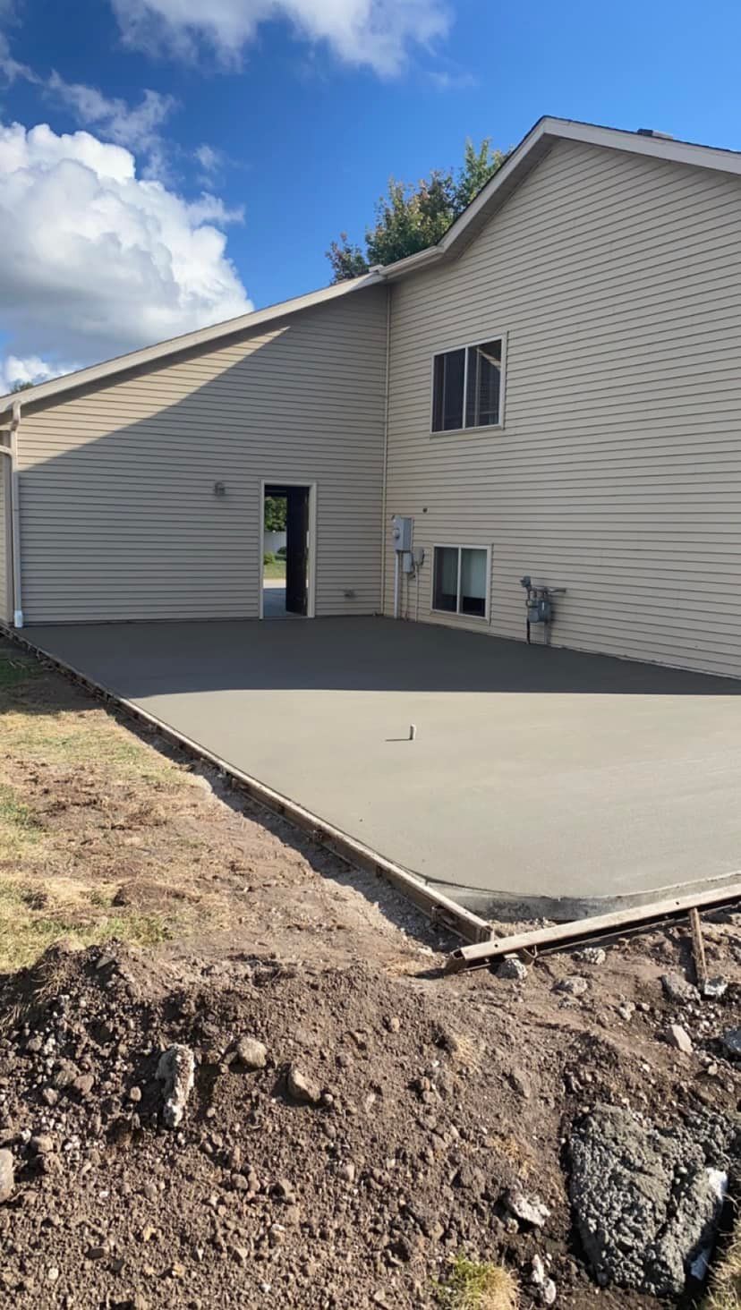 A house with a concrete driveway in front of it.