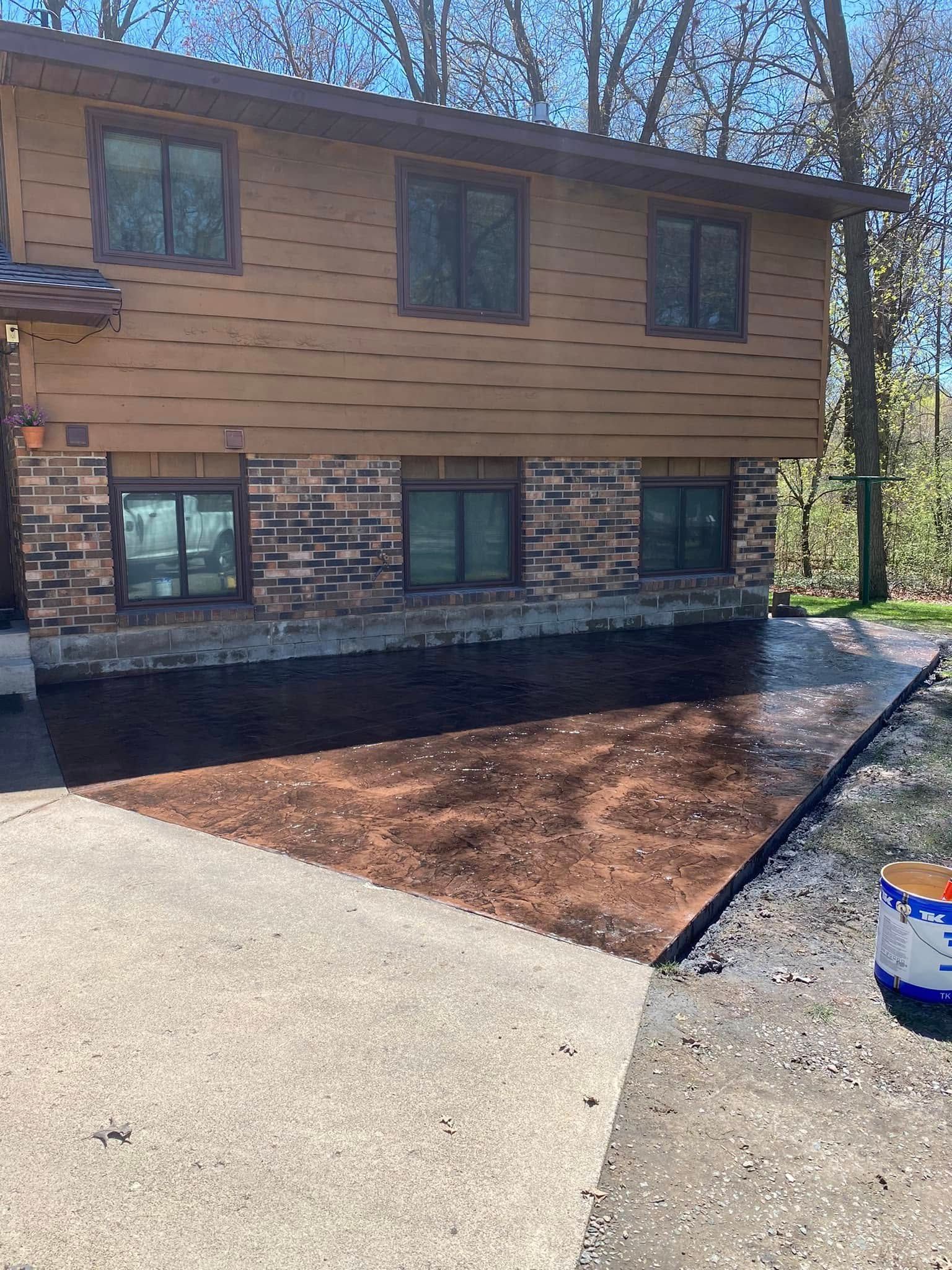 A house with a concrete driveway in front of it.