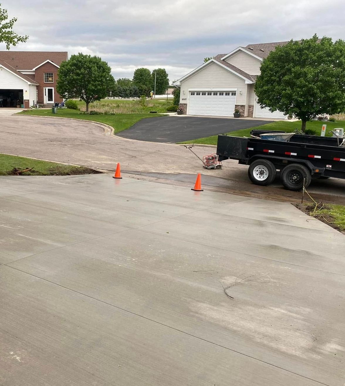A dump truck is parked in a driveway in front of a house