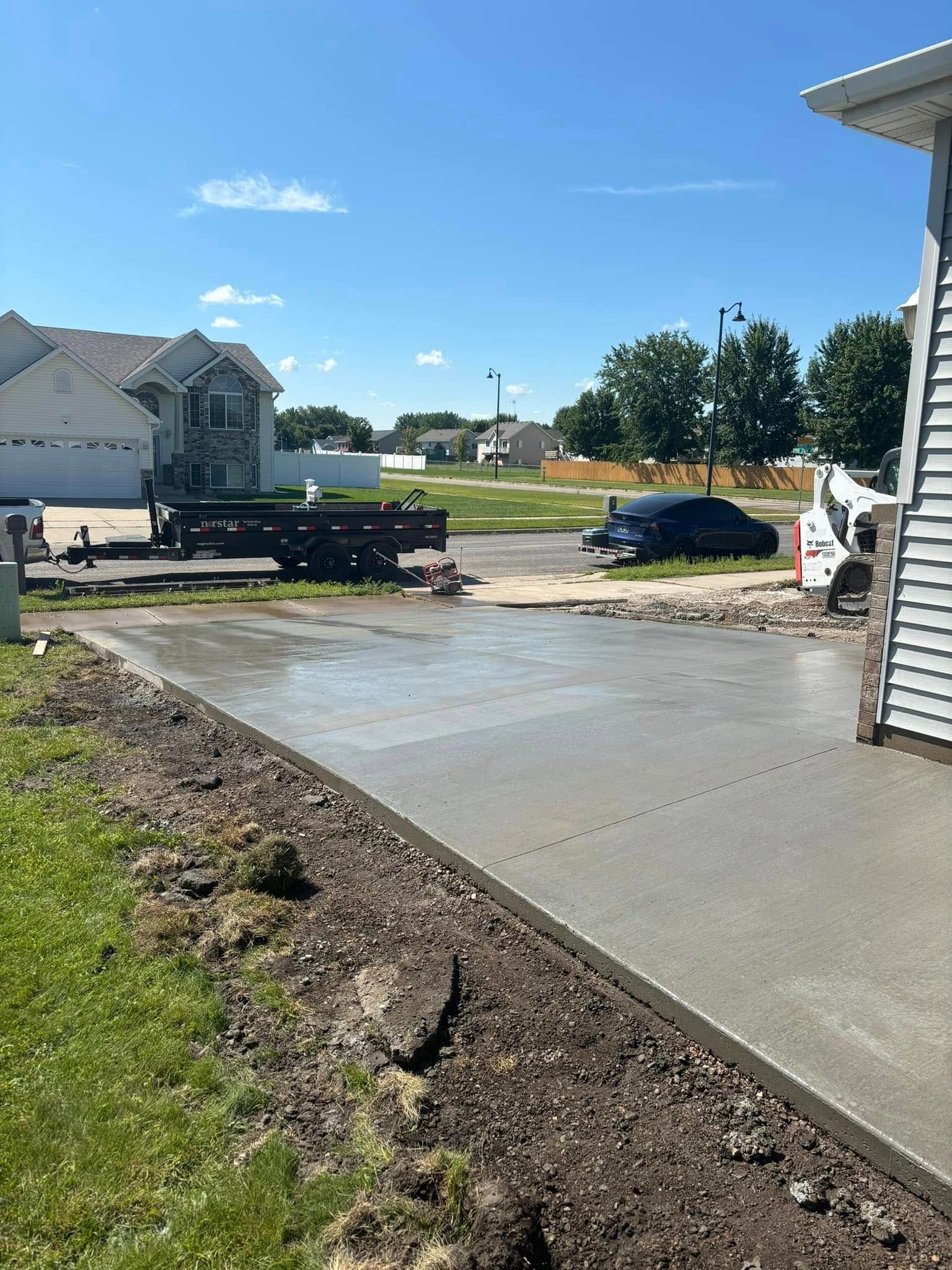 A concrete driveway is being built in front of a house.