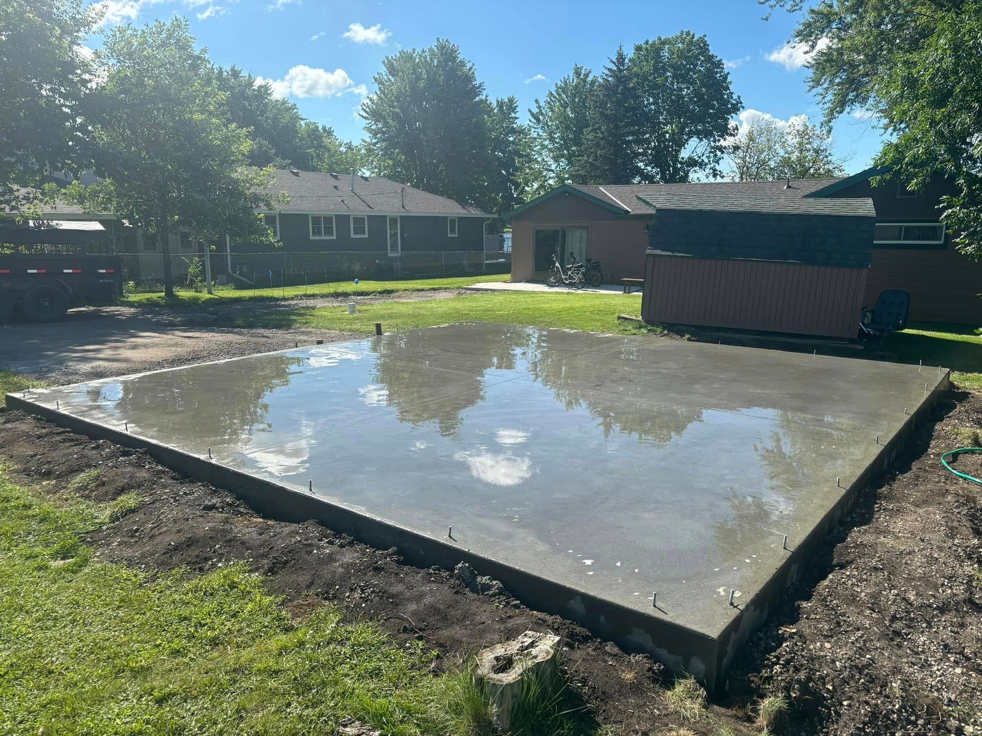 A large concrete slab is sitting in the middle of a lush green yard.