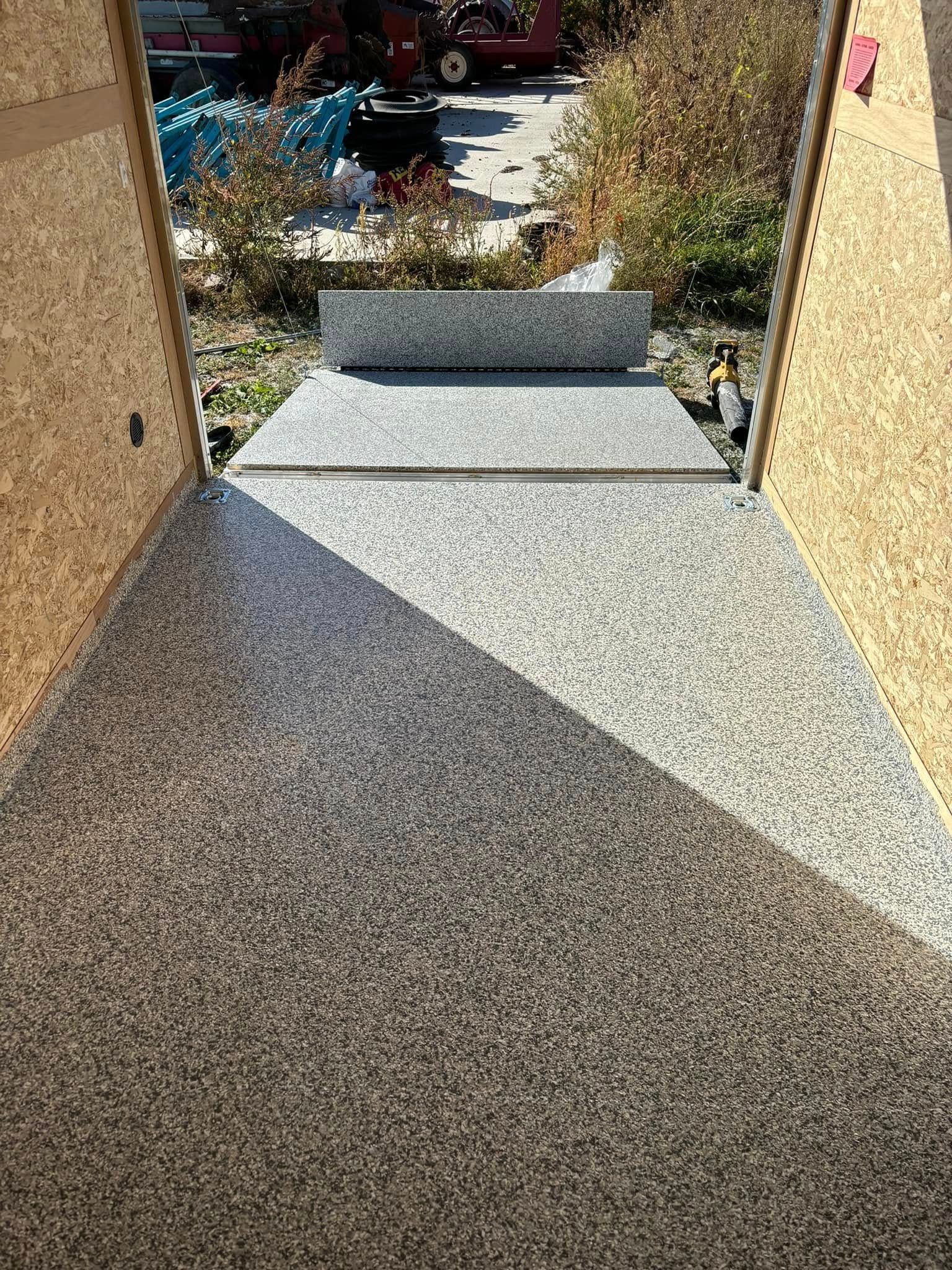 A staircase leading up to a house with a concrete floor.