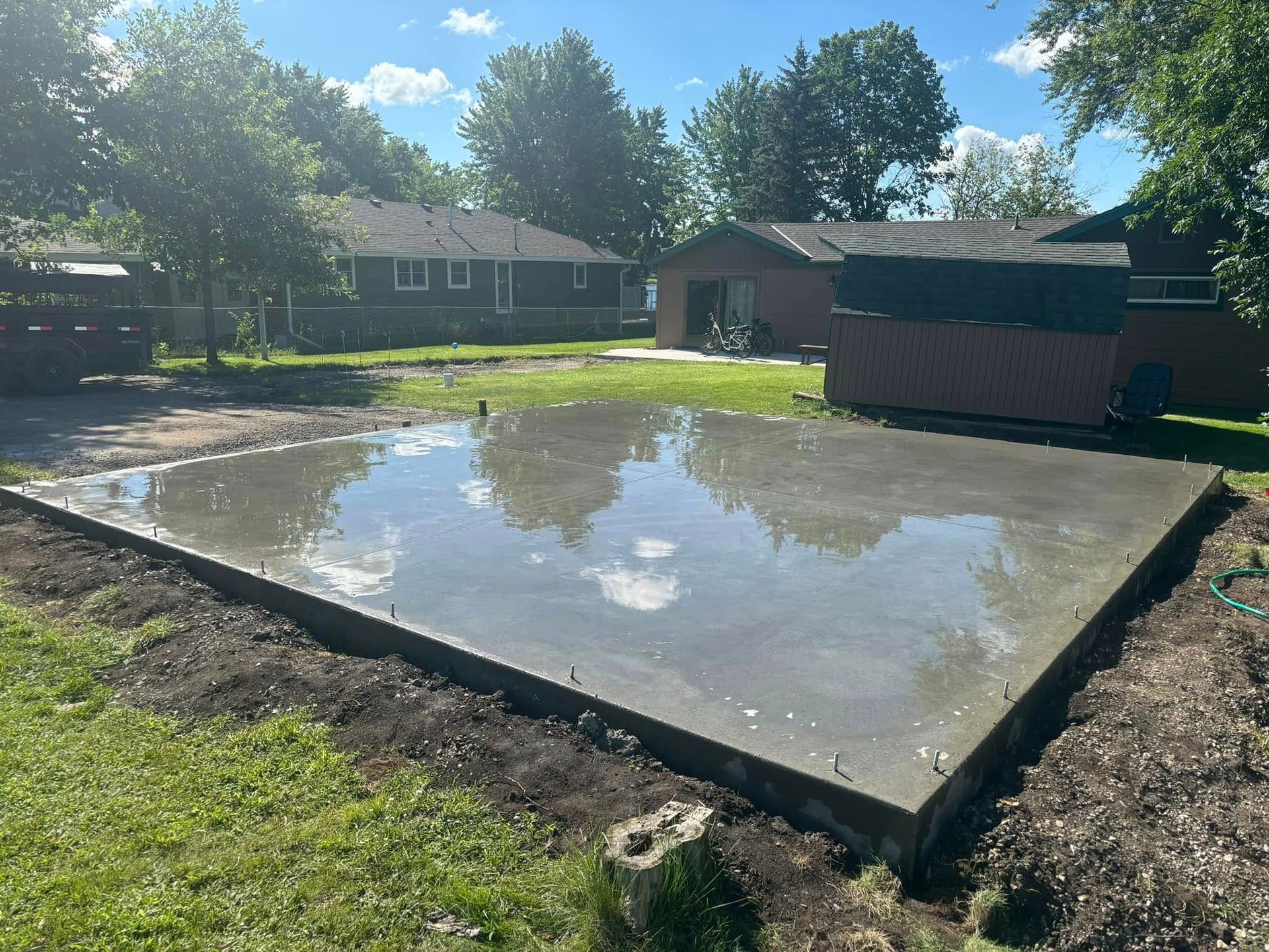 An empty barn with a concrete floor and a wooden roof. Project done by Raise the Bar Construction