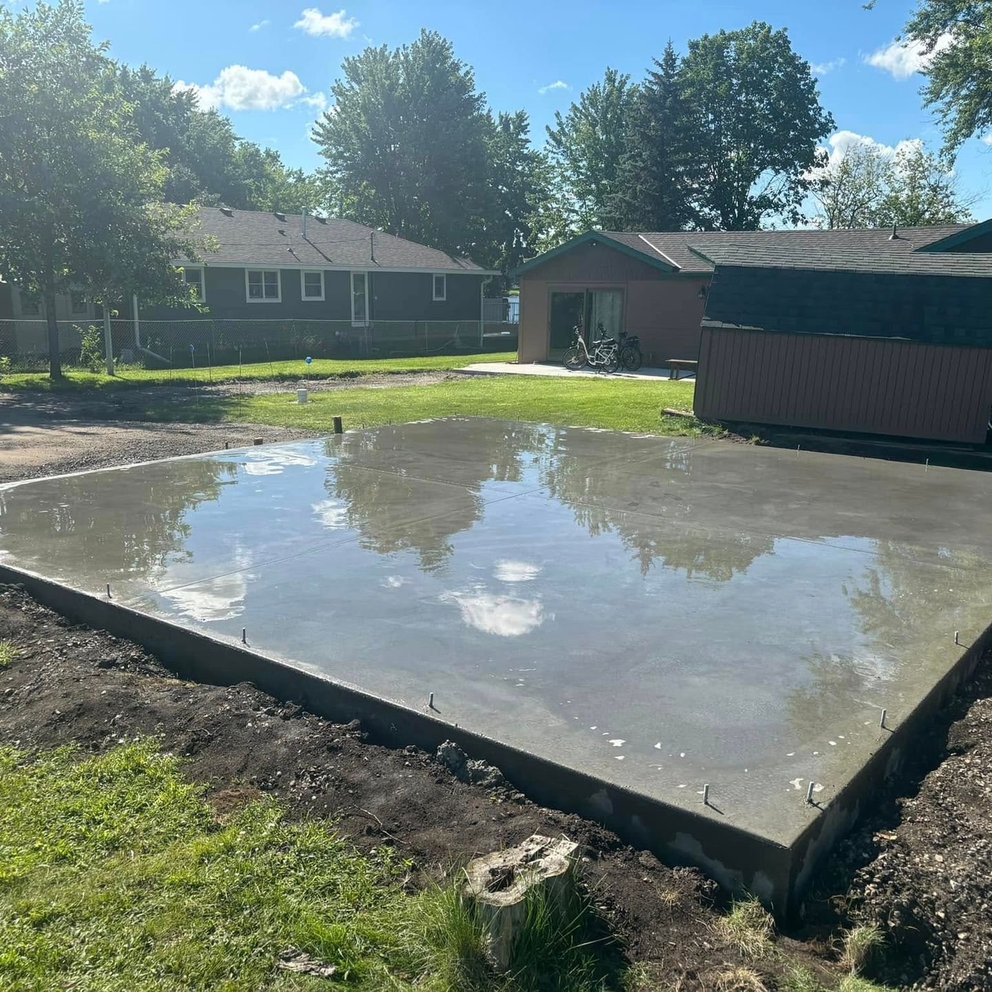 An empty barn with a concrete floor and a wooden roof. Project done by Raise the Bar Construction
