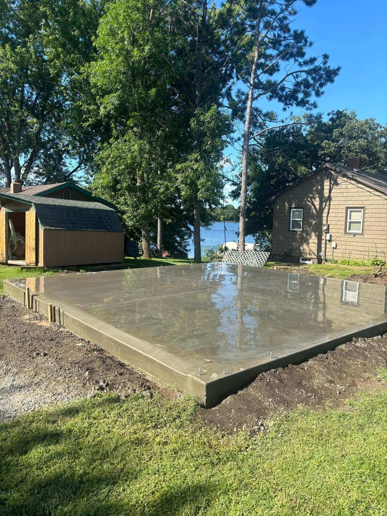 A concrete slab is sitting on top of a lush green lawn in front of a house.
