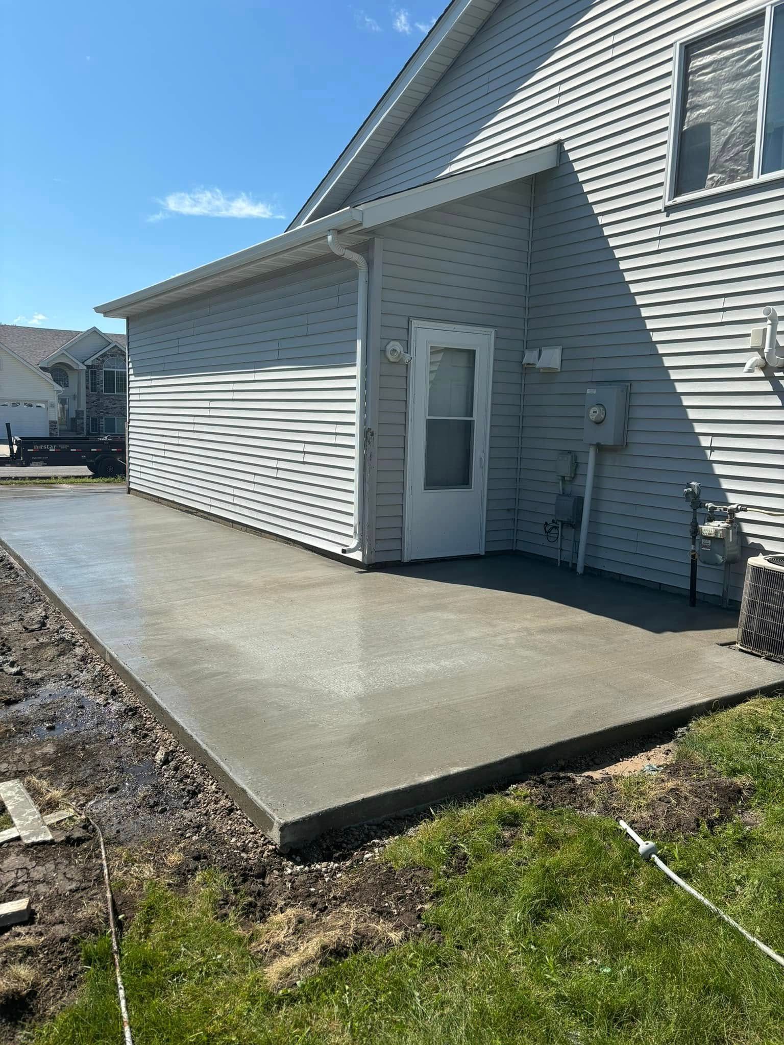 A concrete walkway is being built in front of a house.