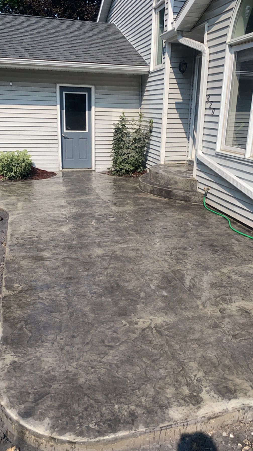 There is a concrete patio in front of a house.