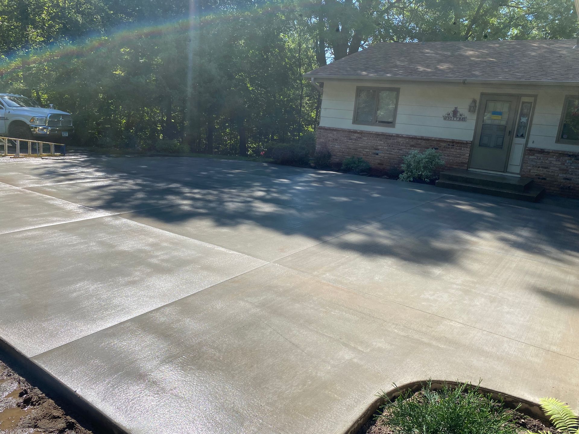 A concrete driveway is being built in front of a house.