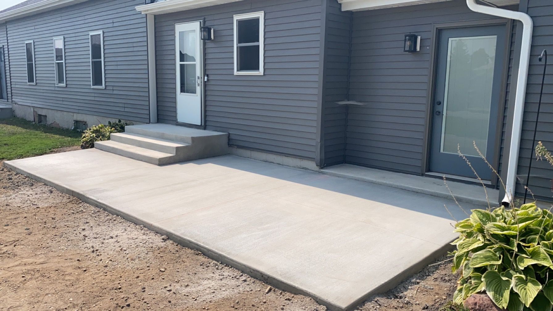 A concrete walkway is being built in front of a house.
