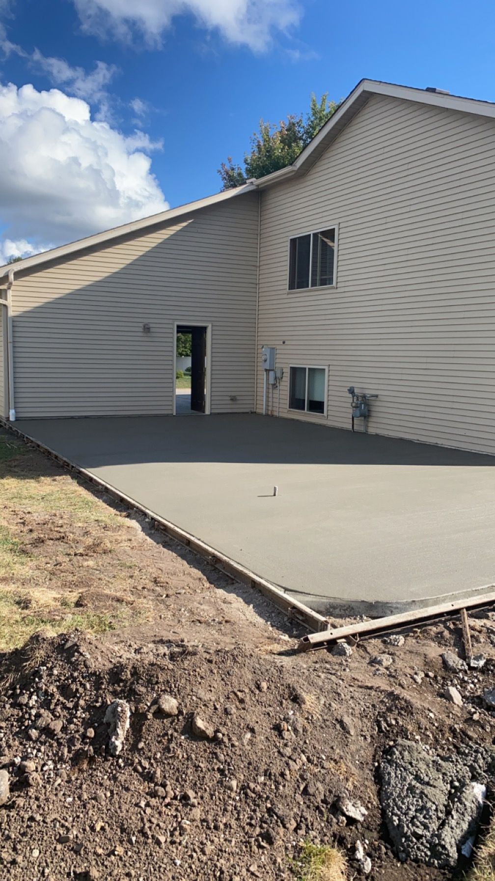 A concrete driveway is being built in front of a house.