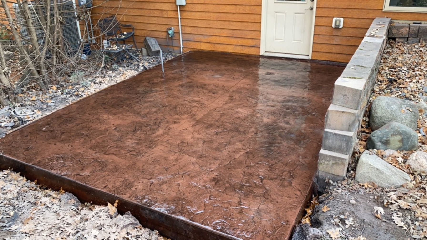 A concrete patio is being built in front of a house.